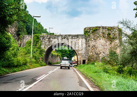 Zvornik, Bosnia and Herzegovina - July 31, 2019. Vintage car going on the asfphalt road through the fort gate Stock Photo
