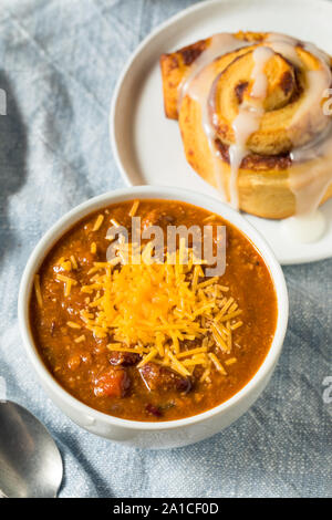 Homemade Chili Soup and Cinnamon Roll for Lunch Stock Photo