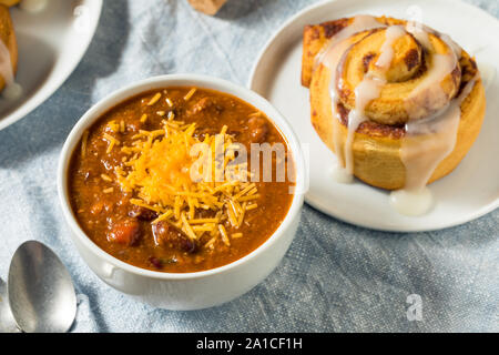 Homemade Chili Soup and Cinnamon Roll for Lunch Stock Photo