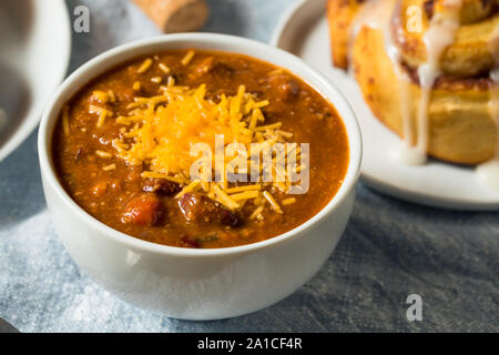 Homemade Chili Soup and Cinnamon Roll for Lunch Stock Photo
