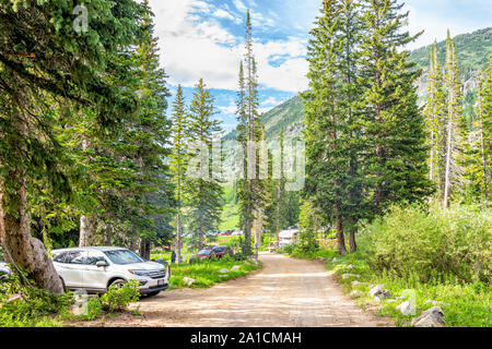 Alta, USA - July 25, 2019: Campsites with cars and dirt road in Albion Basin, Utah summer in Wasatch mountains with nobody Stock Photo