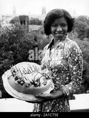 Sep. 29, 1976 - London, England, United Kingdom - NATALIE COLE, 26, is in London to make her British concert debut. Cole, winner of two Grammies at the 1976 Awards presentations, including Best New Artist of the Year, recently completed a highly successful tour of Japan, which included a prize-winning appearance at the Tokyo Music Festival. She will make her first concert appearance at the New Victoria Theatre in London on Thursday September 30th. Cole holds a special cake with her name on it, baked for her by a chef at Crockfords where there was a reception today. (Credit Image: © Keystone Pr Stock Photo