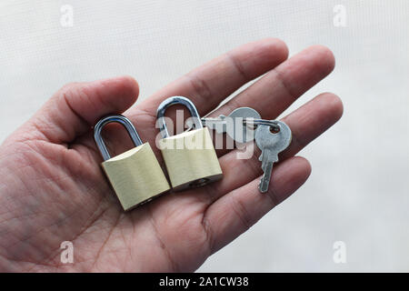 Hand holding Keys and padlocks isolated against white background Stock Photo