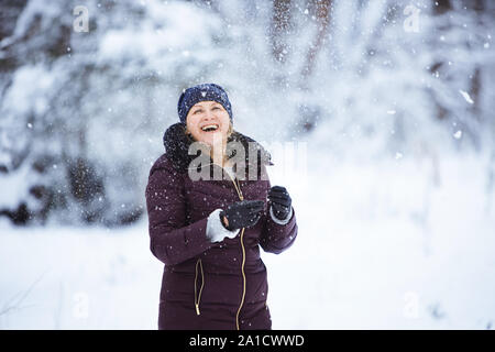 young caucasian woman is playing in the snow Stock Photo