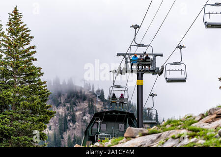 Alta, USA - July 27, 2019: Albion Basin, Utah summer with people ridging ski lifts in summer in Wasatch mountains with mist fog in morning Stock Photo
