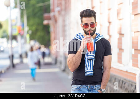 https://l450v.alamy.com/450v/2a1d4gg/cute-stylish-arab-young-male-hipster-with-a-mustache-and-a-beard-and-wearing-glasses-drinking-juice-with-a-straw-summer-vacation-concept-2a1d4gg.jpg