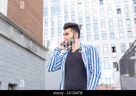 Modern arab young man with mobile phone in the street. Outdoor portrait Stock Photo