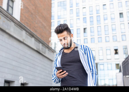 Modern arab young man with mobile phone in the street. Outdoor portrait Stock Photo
