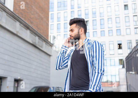 Modern arab young man with mobile phone in the street. Outdoor portrait Stock Photo