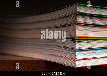 a stack of multicolored books on a dark background Stock Photo
