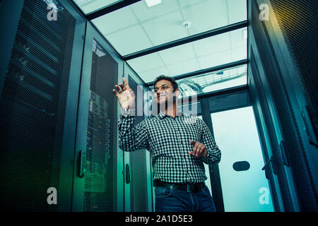 Low angle of a positive smart man using virtual technology Stock Photo