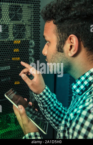 Nice male engineer doing his job in the data center Stock Photo