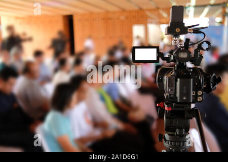 professional video production camera recording live event on stage. television social media broadcasting seminar conference. Stock Photo