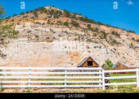 Old vintage wooden farm cabin and fence on road in Grand Staircase Escalante National Monument with canyon formations in Utah summer Stock Photo