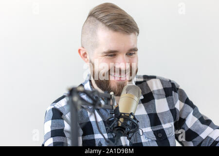 Radio, dj and broadcast concept - Portrait of handsome young man with blond hair hosting show live in studio. Stock Photo