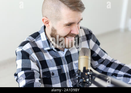 Radio, dj and broadcast concept - Portrait of handsome young man with blond hair hosting show live in studio. Stock Photo