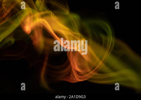 Yellow smoke, and red on black background Stock Photo