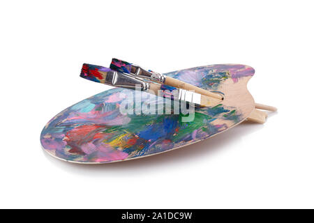 Wooden palette with paints and brushes isolated on white background Stock Photo