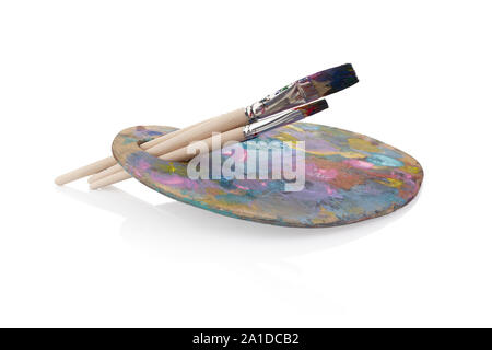 Wooden palette with paints and brushes isolated on white background Stock Photo