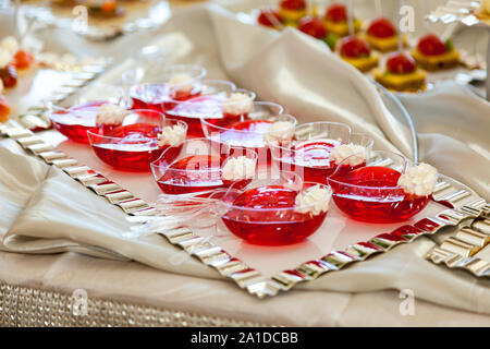 Raspberry Jello with fresh fruits on a festive table close up Stock Photo