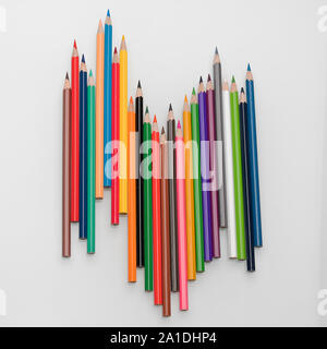 Colored pencils in the form of a wave on a white background Stock Photo