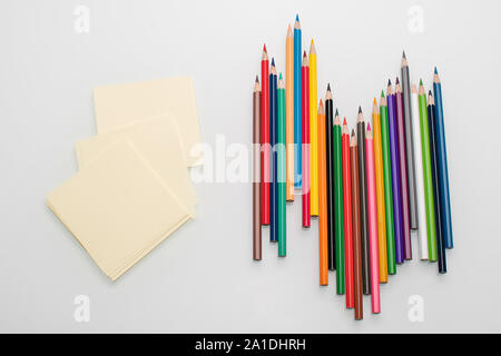 Clean sheets for notes and color pencils on white background top view  Stock Photo