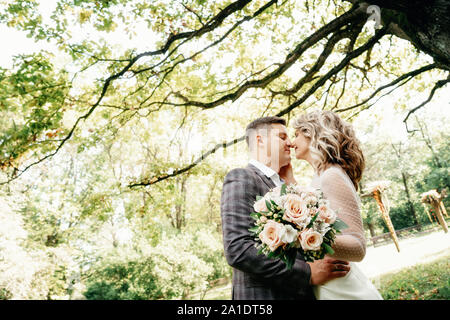 Portrait of kissing couple in the garden against huge oak