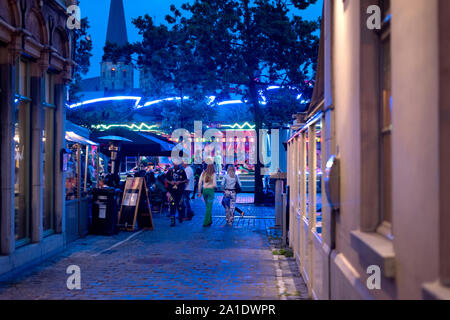 Ghent, East Flanders, Belgium - Fair rides with neon lights and Sint Jacobskerk in the background. Stock Photo