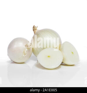 white onions, unpeeled and sliced in front of white Stock Photo