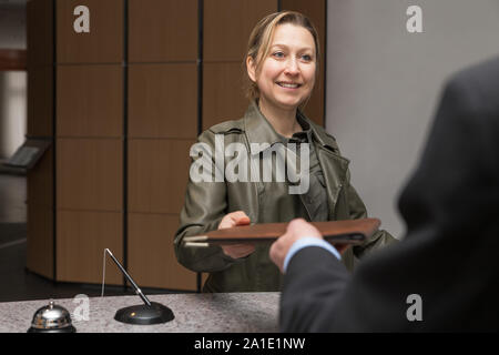female guest in a hotel is checking in Stock Photo