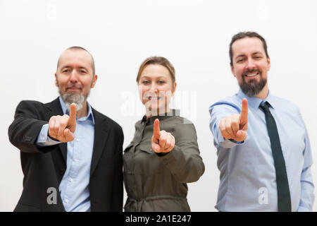 three business woman and men are pointing with their fingers to the viewer Stock Photo