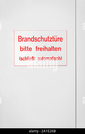 sign with red coloured letters on a white door, with german words which means fire emergency door Stock Photo