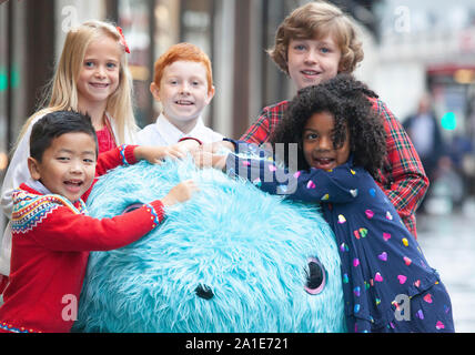 A few lucky children got a trip to Hamleys for the launch of their 10 Toys For Christmas on Regent Street. Here the kids cuddle around a giant Scruf-a-Luv toy. Stock Photo