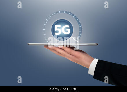 Man holding a digital tablet with symbol of 5G network connection. Stock Photo