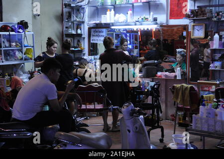 Open air street hairdresser, beauty salon in the red light district at night, Phnom Penh, Cambodia. credit: Kraig Lieb Stock Photo
