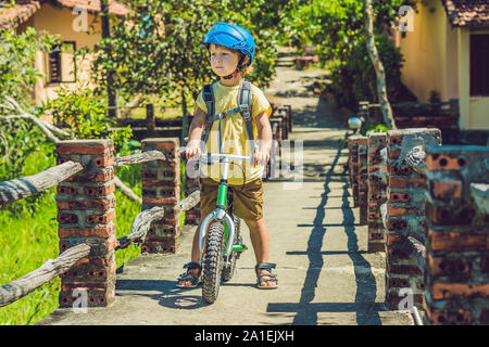 Little boy on a bicycle. Caught in motion, on a driveway motion blurred. Preschool child's first day on the bike. The joy of movement. Little athlete Stock Photo