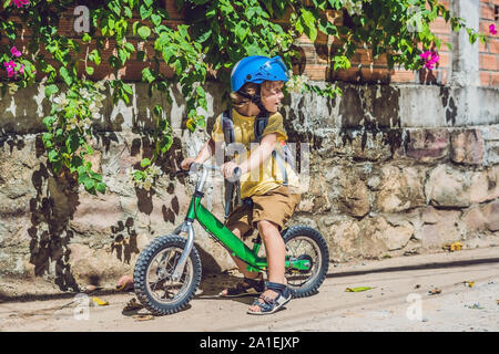 Little boy on a bicycle. Caught in motion, on a driveway motion blurred. Preschool child's first day on the bike. The joy of movement. Little athlete Stock Photo