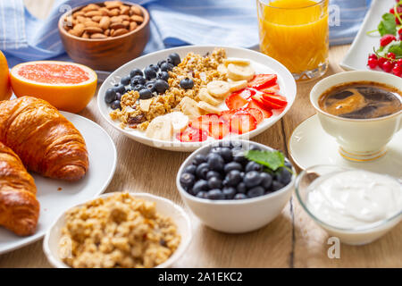 Healthy breakfast served with plate of yogurt muesli blueberries strawberries and banana. Stock Photo