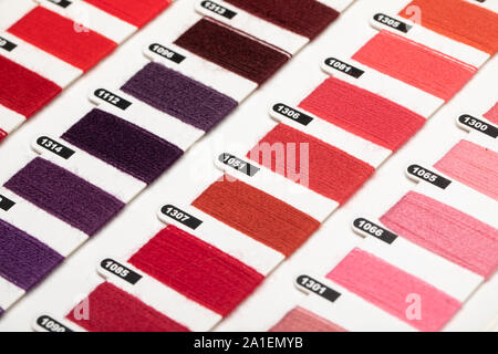 Red violet and pink color hue yarn thread sample swatches close-up Stock Photo