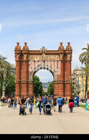 People and tourists at the Arc de Triomf or Arco de Triunfo landmark arch and boulevard in summer sunshine, Barcelona, Spain Stock Photo