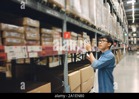 Portrait Asian men, staff, product counting Warehouse Control Manager Standing, counting and inspecting products in the warehouse Stock Photo