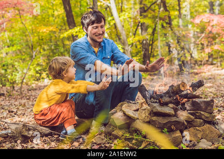 Happy father doing barbecue with his son on an autumn day. Stock Photo