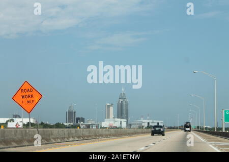 Road sign saying 'ROAD WORK, 1 MILE' in Pensacola, Florida highway. Stock Photo