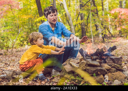 Happy father doing barbecue with his son on an autumn day. Stock Photo