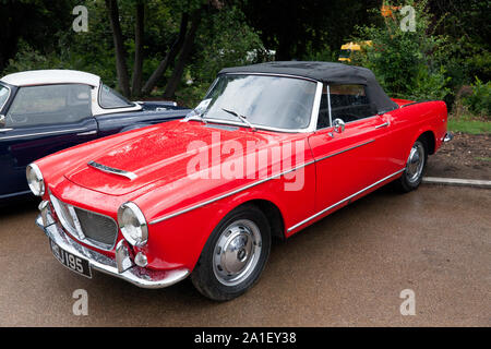 Three-quarters front view of a Red,1962 Fiat 1200 Cabriolet on display outside the Mansion in Beckenham Place Park, Lewisham Stock Photo