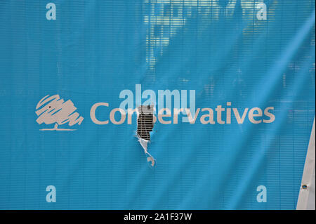 Manchester, UK. 26 September 2019. A torn Conservative Party banner on security fencing erected outside the Midland Hotel for the Conservative Party Conference. The Conference takes place at the adjacent Manchester Central Convention Complex and is expected to attract 11,500 people to the city centre venue. G.P. Essex/Alamy Live News Stock Photo