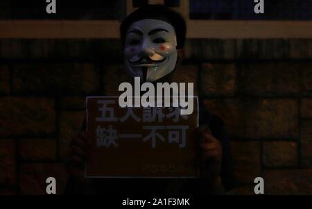 September 26, 2019, Hong Kong, CHINA: Citizen disguised as GUY FAWKES displaying a placard in protest calling for 'all FIVE DEMANDS be met, not one less' during human-chain protest in WanChai.Sept-26,2019 Hong Kong.ZUMA/Liau Chung-ren (Credit Image: © Liau Chung-ren/ZUMA Wire) Stock Photo