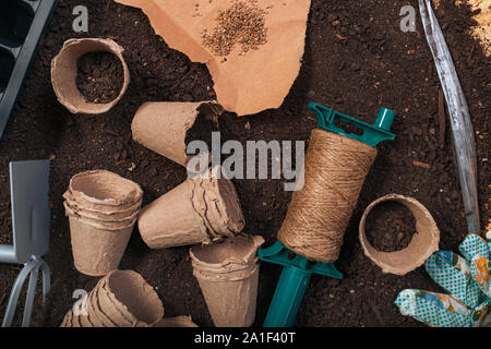 Biodegradable flowerpots in soil, tools and equipment for agricultural activity, top view Stock Photo