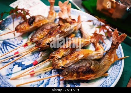 Grilled fishes on sticks as street food at Nishiki market, Kyoto Stock Photo