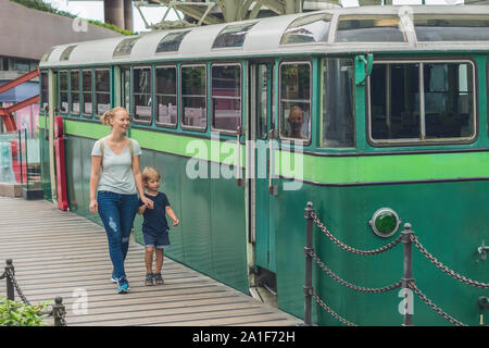 Mom and son are going to go on an old tram. Traveling with children in Hong Kong concept. Stock Photo